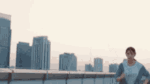 a person is running on a rooftop in front of a city skyline .