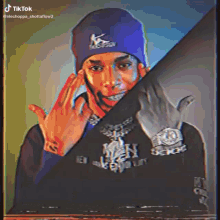 a man wearing a blue beanie and a black shirt with a watch
