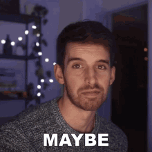 a man with a beard is wearing a grey sweater and has the word maybe above his head