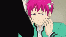 a person with pink hair is touching another person 's face with their hands