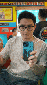 a man taking a selfie with a phone that says 280-609 on the back