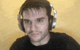a man wearing headphones is looking at the camera and smiling