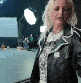 a woman wearing a black leather jacket has a cadillac pin on her sleeve