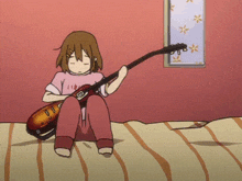 a girl sitting on a bed playing a guitar with a shirt that says ' i love you ' on it