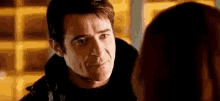 a man and a woman are looking at each other and the man is looking at the woman .