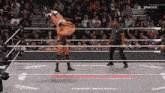 a wrestler is being lifted in the air by another wrestler in a wrestling ring sponsored by peacock