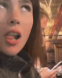a close up of a woman 's face with a surprised look on her face