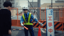 a woman in a yellow vest stands next to a sign that says 0 m