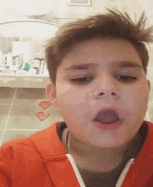 a young boy making a funny face in front of a bathroom mirror