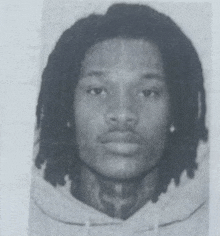 a black and white photo of a man with dreadlocks and a tattoo on his neck
