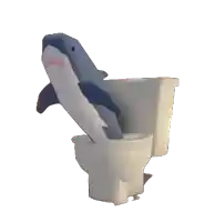 a stuffed shark sitting on top of a toilet