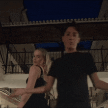 a man and woman are dancing together in a dark room
