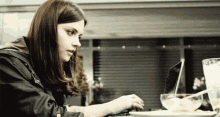 a woman is sitting at a table using a laptop computer