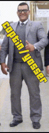 a man in a suit and tie is holding a banner that says ayogin / yusgar