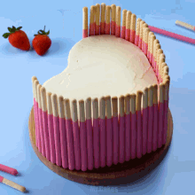 a heart shaped cake with pink and white sticks on it