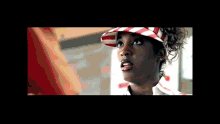 a woman wearing a red white and blue striped hat and visor