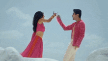 a man in a pink shirt is standing next to a woman in a pink top .