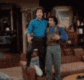 two men standing next to each other in a living room with imgflip.com at the bottom