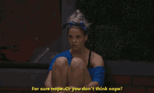 a woman in a blue shirt sits on the ground and says " for sure nope or you don t think nope "