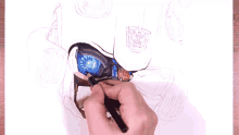a person is drawing a robot with a pencil on a piece of paper