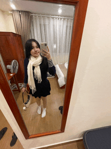 a woman taking a selfie in a mirror with her phone