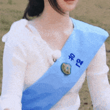 a woman wearing a blue sash with chinese writing