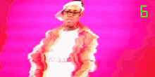 a man in an orange jacket and white shirt is dancing in front of a pink background with the number 8 on it .