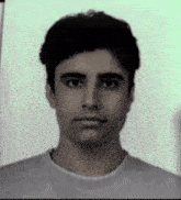 a black and white photo of a young man in a white shirt