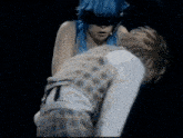 a man and a woman are standing next to each other on a stage in a dark room .