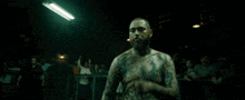 a man with a tattoo on his arm is fighting another man in a boxing match