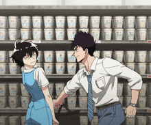 a man and a woman are standing in front of a shelf full of cups with the numbers 1 2 and 3 on them