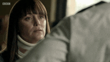 a woman wearing a neck brace looks at a man in a bbc advertisement
