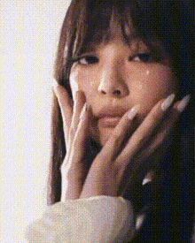 a close up of a woman 's face with a tear coming out of her eye .
