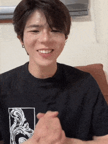 a young man wearing a black t-shirt with the letter o on it