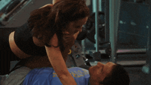 a woman laying on top of a man wearing a blue shirt that says ' ucsd ' on it