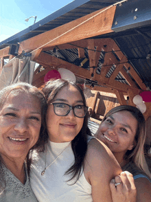 three women posing for a picture with one wearing a ring