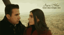 a man and a woman are looking at each other with the words aşk ve mavi written on the bottom