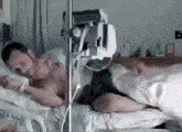 a man is laying in a hospital bed with a drip attached to his arm