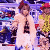 a woman in a fur coat is dancing in front of a sign that says ' yes ' on it .