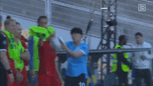 a group of soccer players are standing on a field holding a soccer ball .