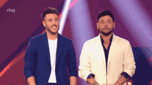 two men standing next to each other on a stage with the word rtve on the bottom