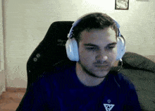 a man wearing headphones is sitting in a chair that says " cad " on it