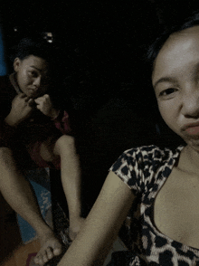 a girl in a leopard print shirt sits next to a boy in a red shirt