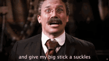 a man with glasses and a mustache says " and give my big stick a suckles "