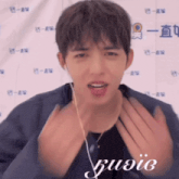 a young man wearing ear buds and a black shirt with the word music on the front