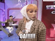 a woman with a bandaged head is holding a microphone and saying oa !!!