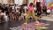 a man is dancing in front of a crowd at a red bull bc one cypher
