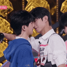 two young men are kissing and one has a sticker on his shirt that says ' a ' on it