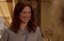 a woman with red hair is smiling in a living room .