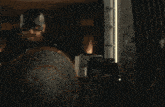 a man is holding a gun in a dark room with boxes on the floor